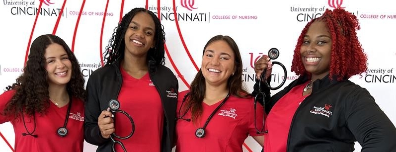 4 female students in red scrubs and bearcat stethoscope